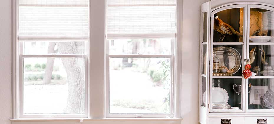 Learn More About White Woven Wood Shades White Woven Wood Shades next to a china hutch