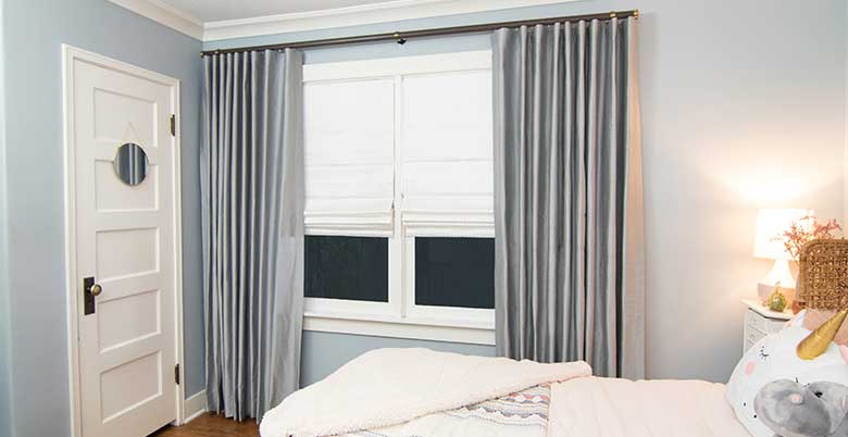 Layered Drapery Panels and Roman Shades in a Bedroom