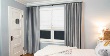 Layered Drapery Panels and Roman Shades in a Bedroom