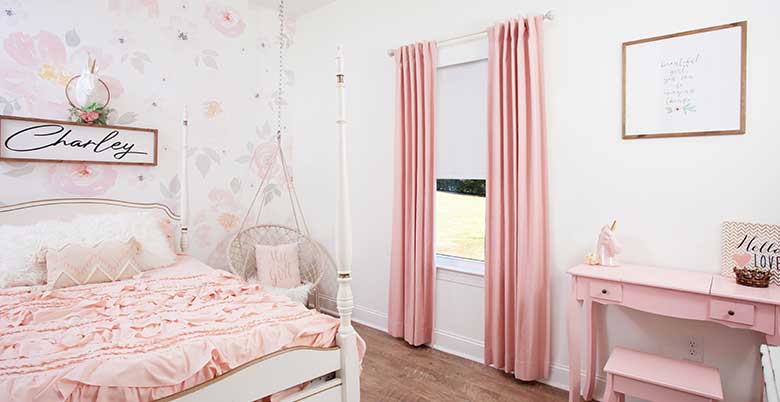 Pink Drapery Panels in Bedroom layered over Roller Shades