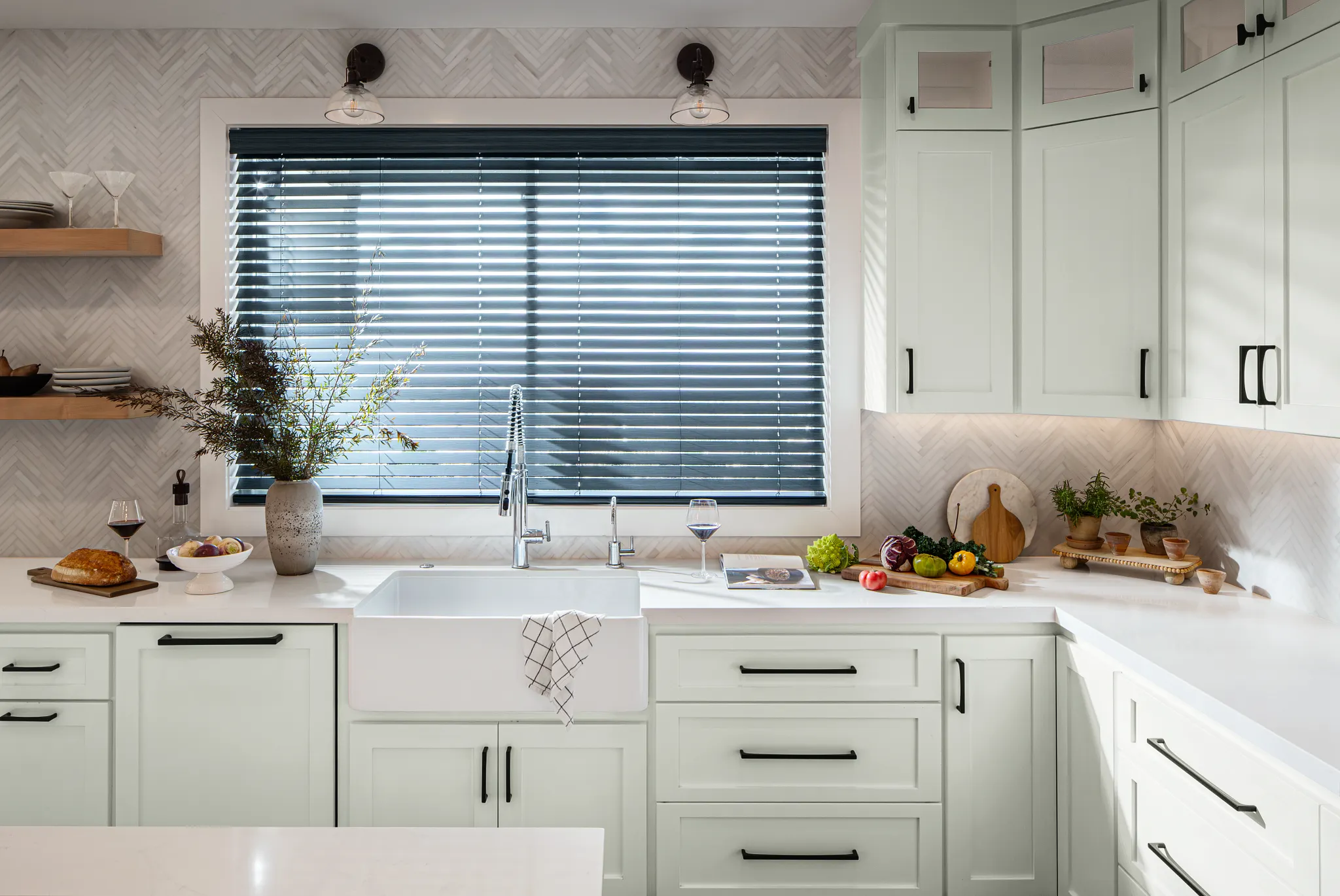 Black Faux Wood Blinds above a farmhouse sink in a bright white kitchen
