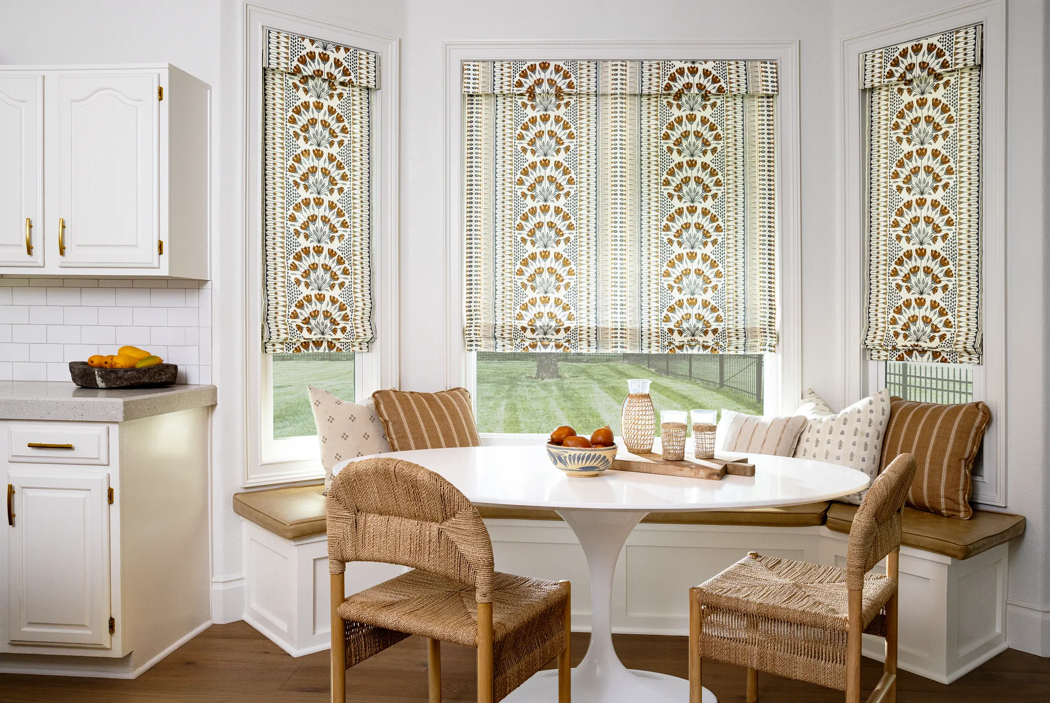 Floral Soft Roman Shades surrounding a bright breakfast nook with a built-in bench