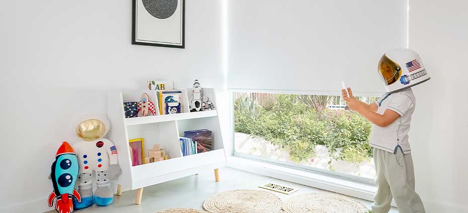 Bedroom-Roller-Shades Childs bedroom with child controlling remote controlled roller shades