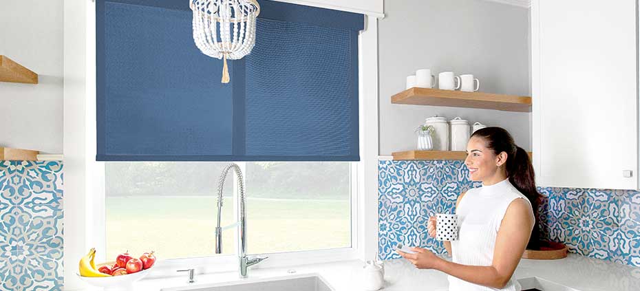 Woman using automated roller shades in her kitchen